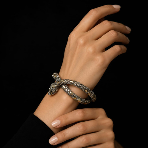Brazalete rígido de plata y oro, en forma de serpiente, contiene iolitas